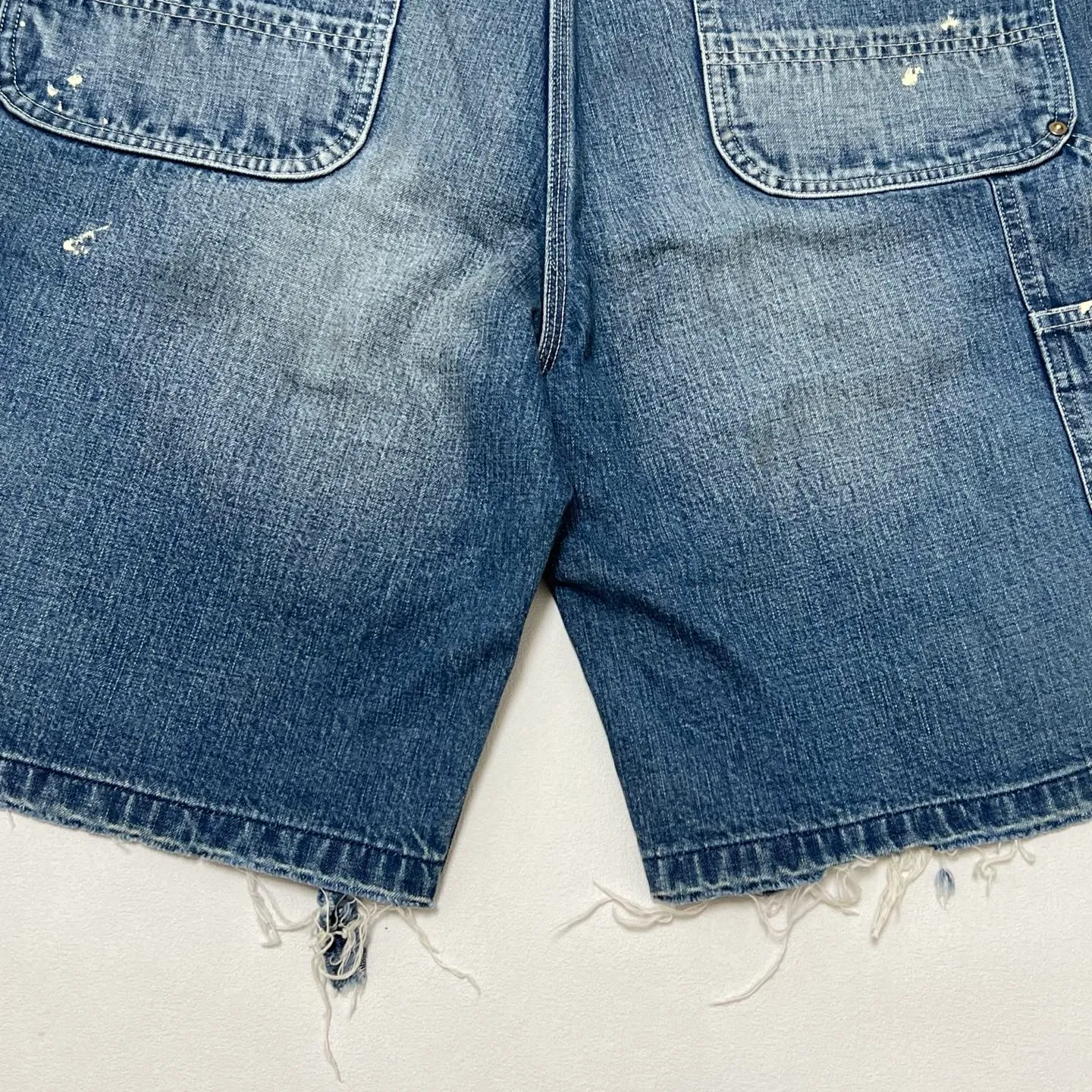SAINT Mxxxxxx DOUBLE KNEE SHORTS/BLU Knee patches splashed with ink and water-splashed denim shorts. Denim blue S-XL. Custom-woven and dyed denim fabric with clear texture. Heavy-wash water-fading treatment to create local mottled fading/hole effects. Artificial distressing to simulate natural wearing marks. VINTAGE sense. Original consistent damage treatment. Hand-splashed ink and paint. Original consistent wash mark/pocket mark. Double knee patch. Rivet reinforcement. Improve functionality while enhancing design